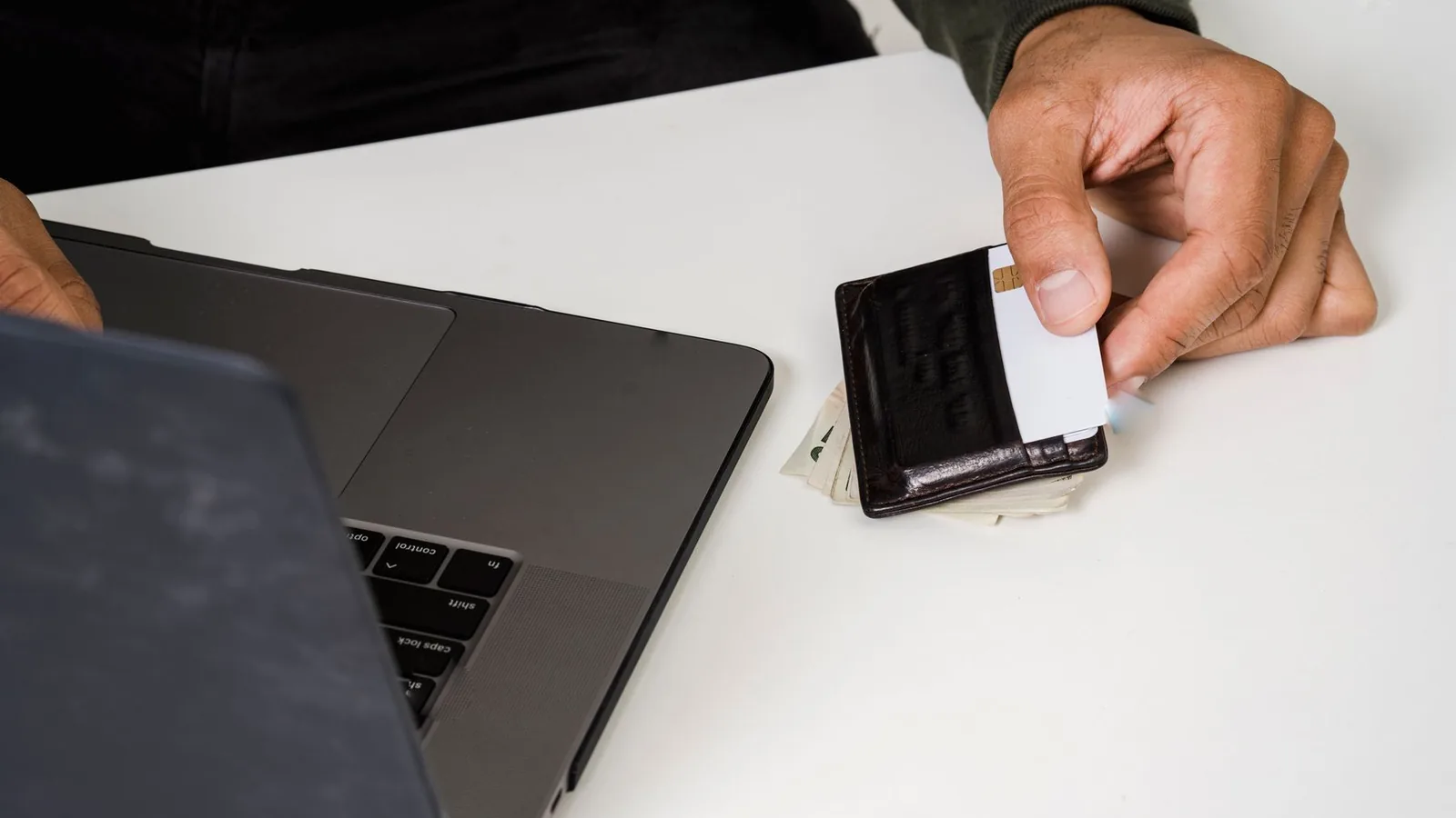 Cartão de crédito ao lado de um laptop
